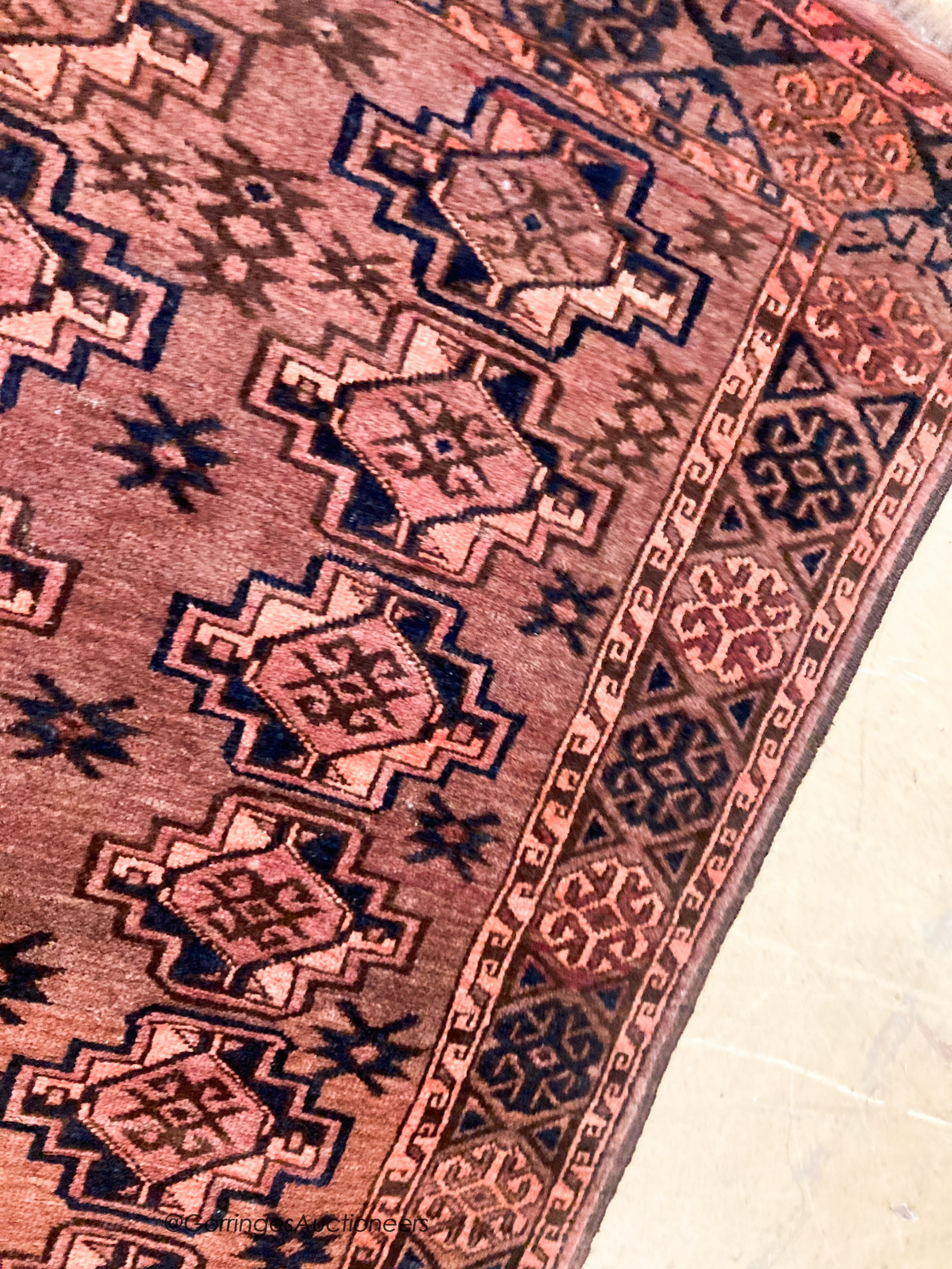 A Bokhara burgundy ground rug, 190 x 105cm